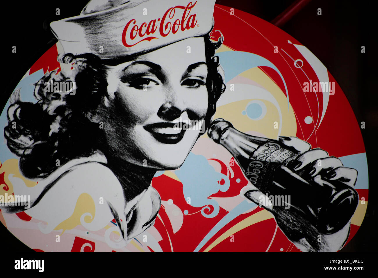 Coca Cola poster with woman in navy cap drinking from bottle Stock Photo