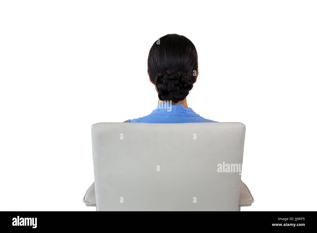Rear view of businesswoman sitting on chair against white background ...