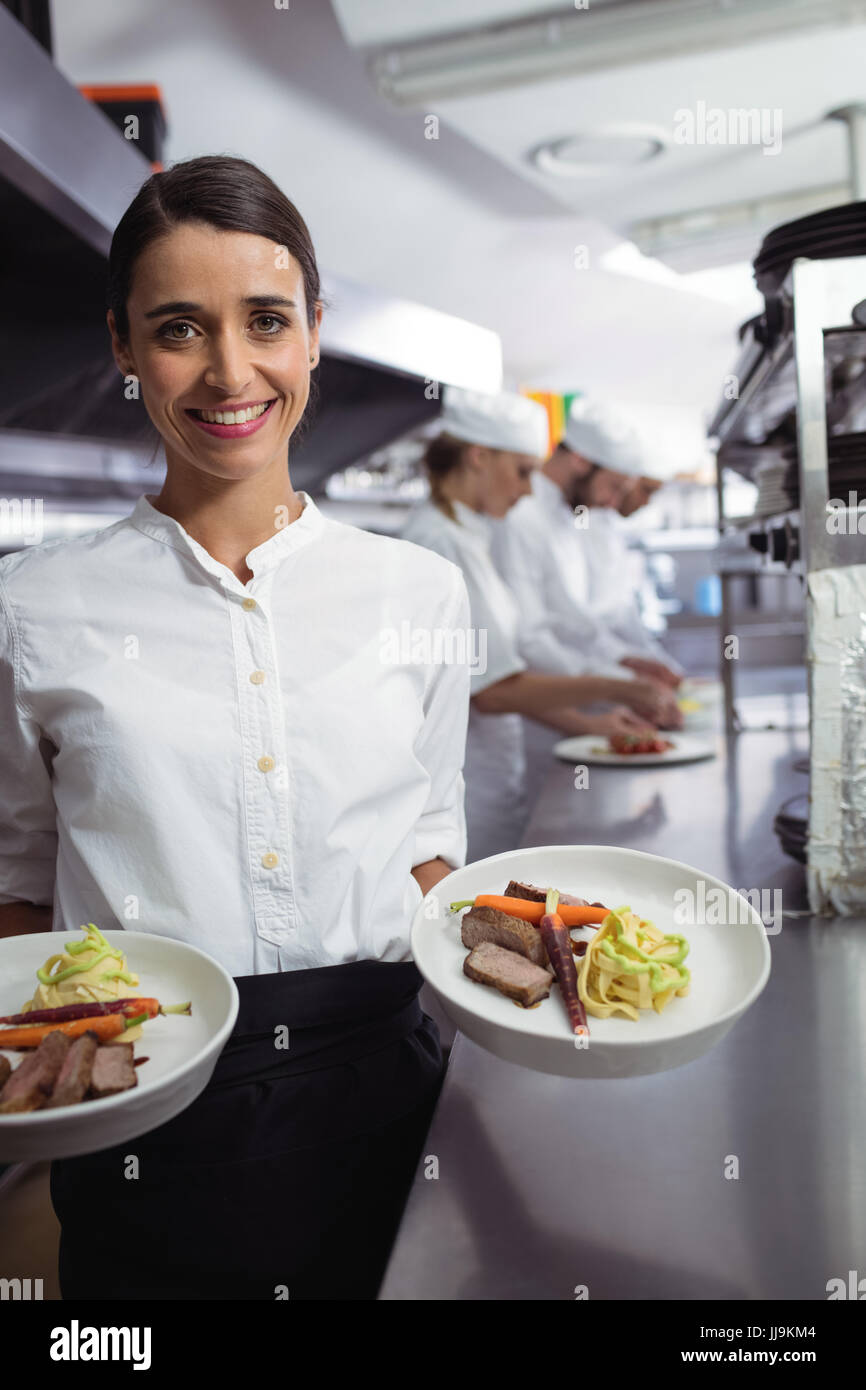 Portrait of chef presenting his food plates in the commercial kitchen Stock Photo