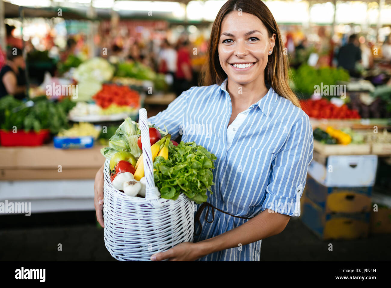 Portrait of beautiful woman holding shopping basket Stock Photo - Alamy