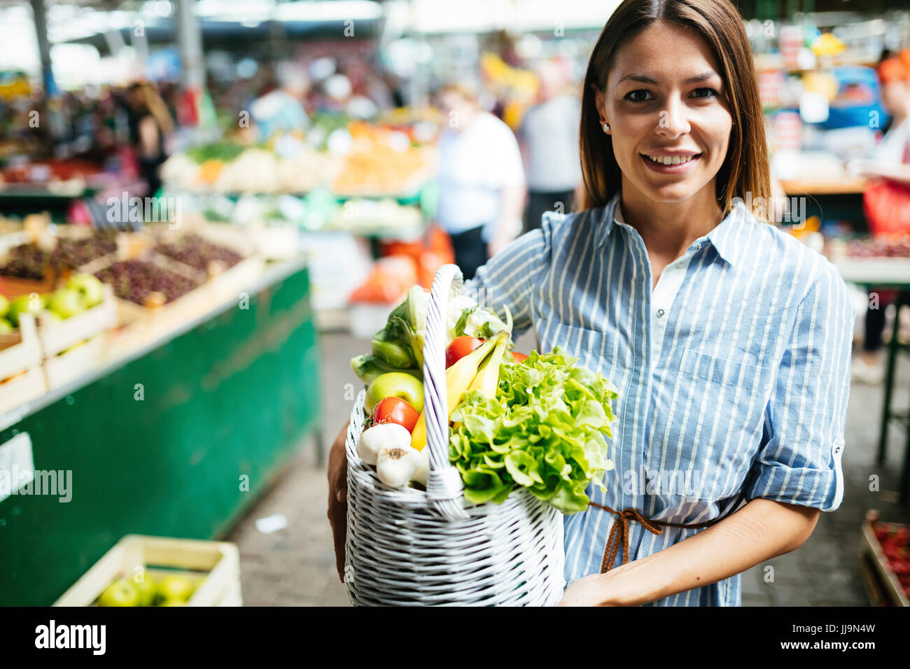 Portrait of beautiful woman holding shopping basket Stock Photo - Alamy