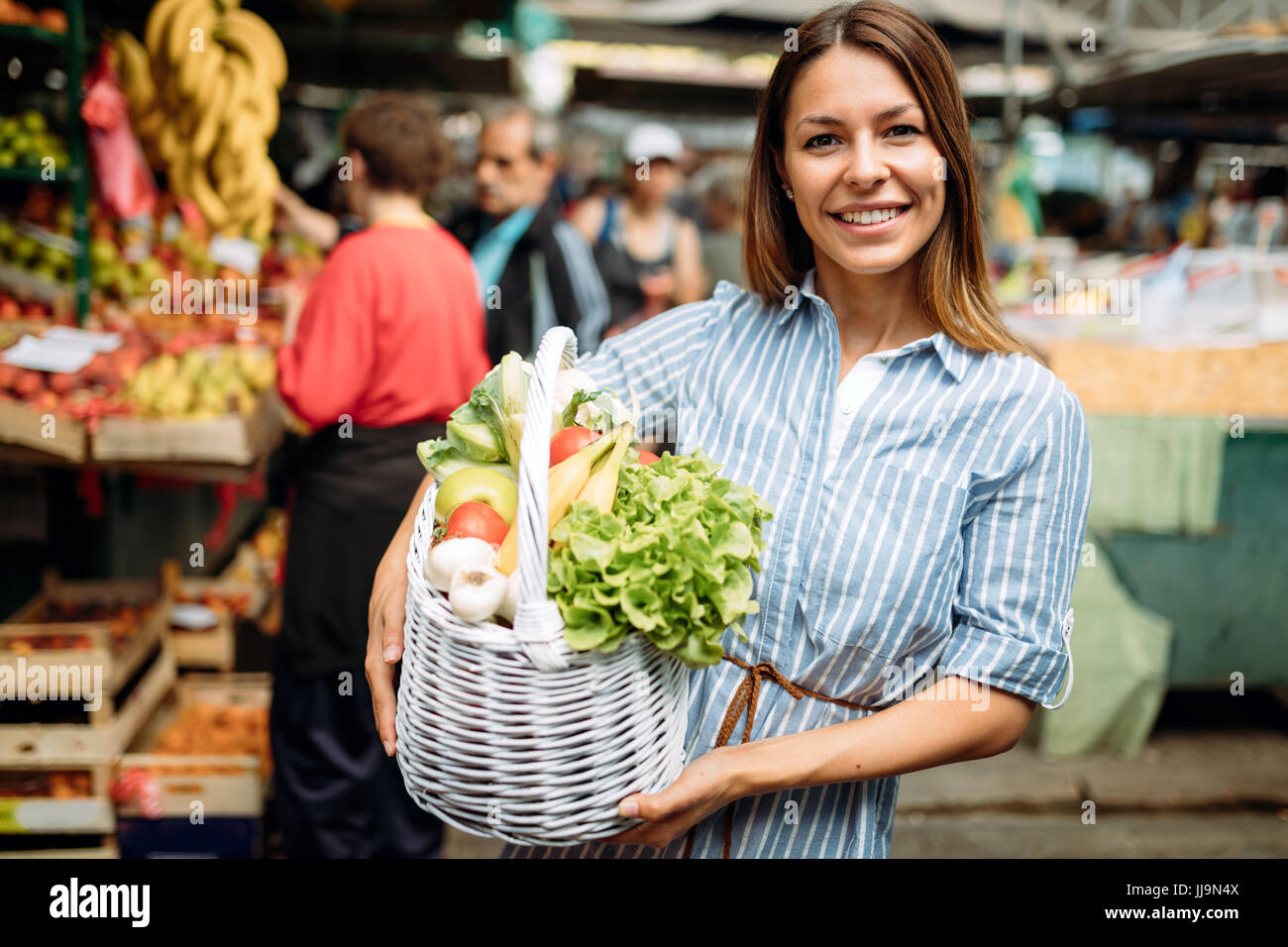 Portrait of beautiful woman holding shopping basket Stock Photo - Alamy