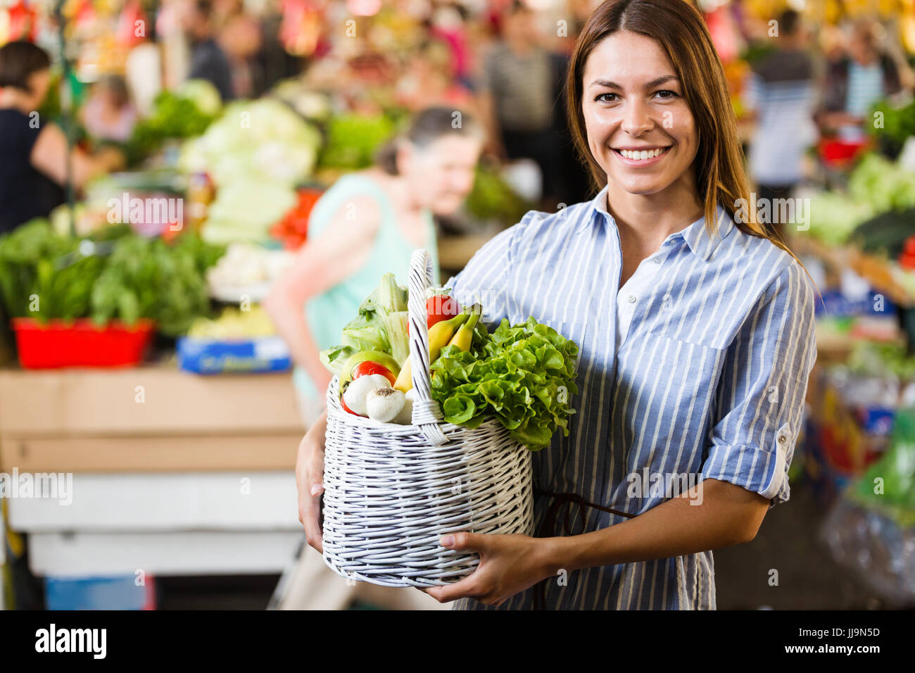 Portrait of beautiful woman holding shopping basket Stock Photo - Alamy