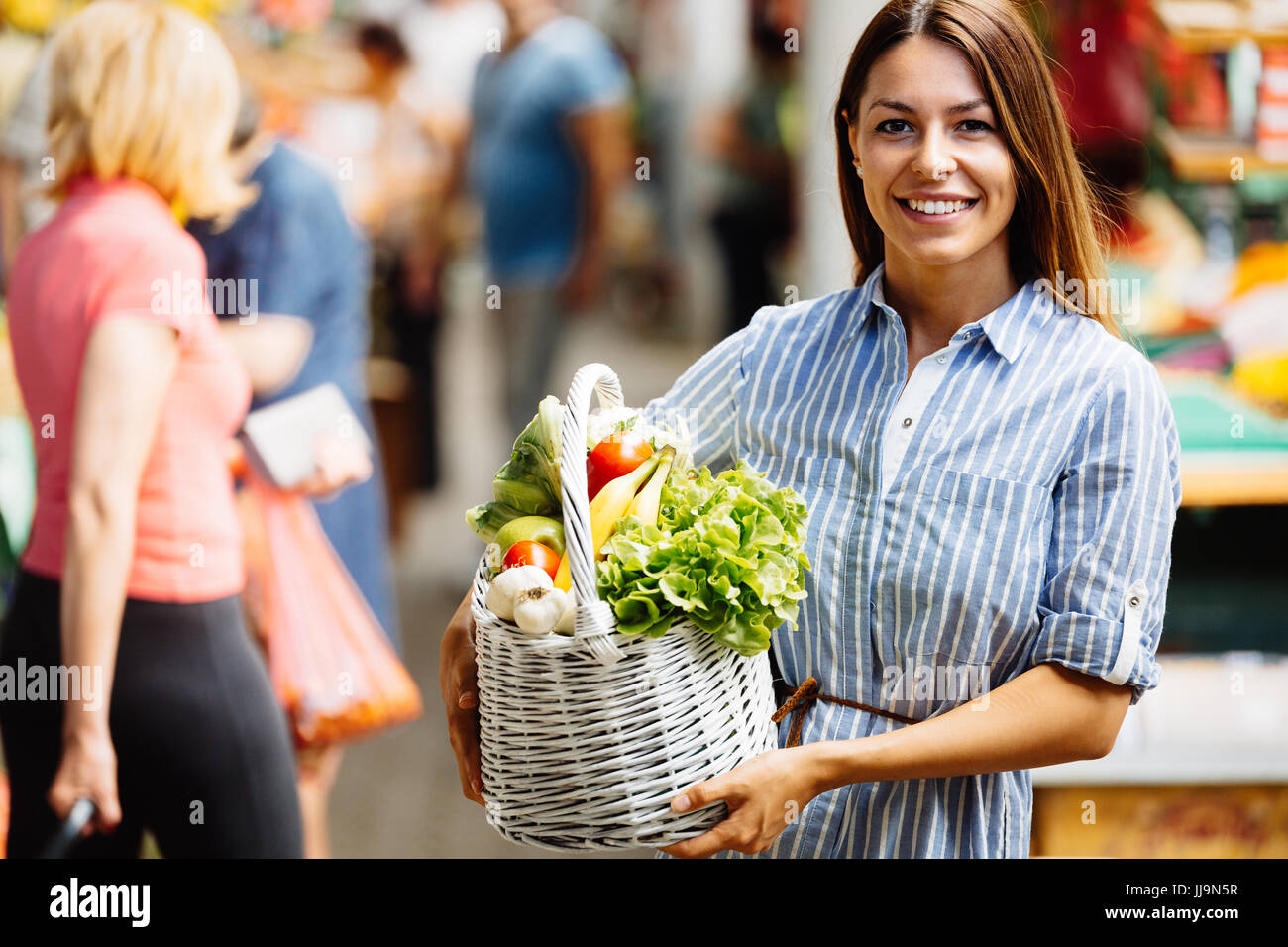 Portrait of beautiful woman holding shopping basket Stock Photo - Alamy