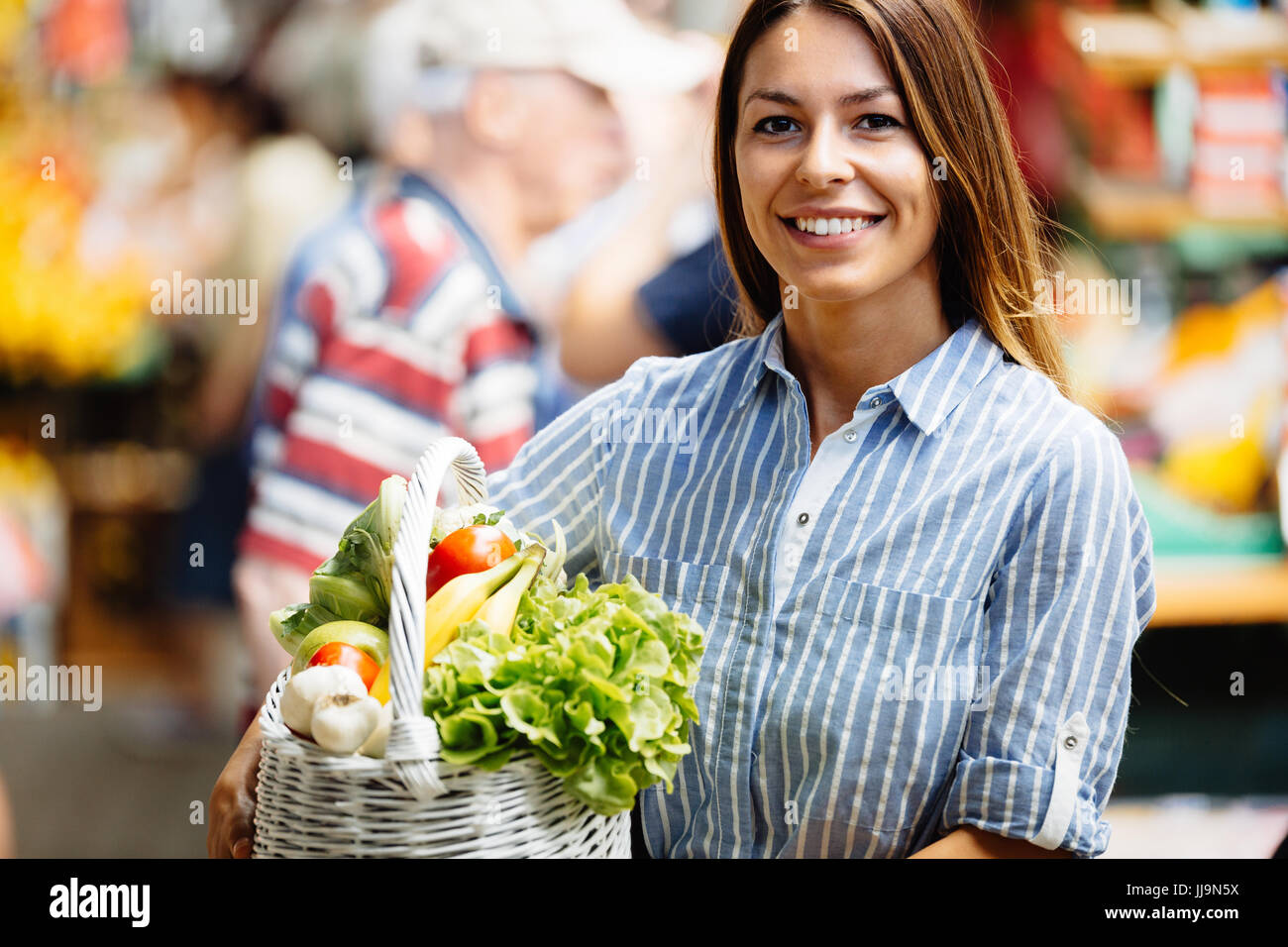 Portrait of beautiful woman holding shopping basket at marketplace