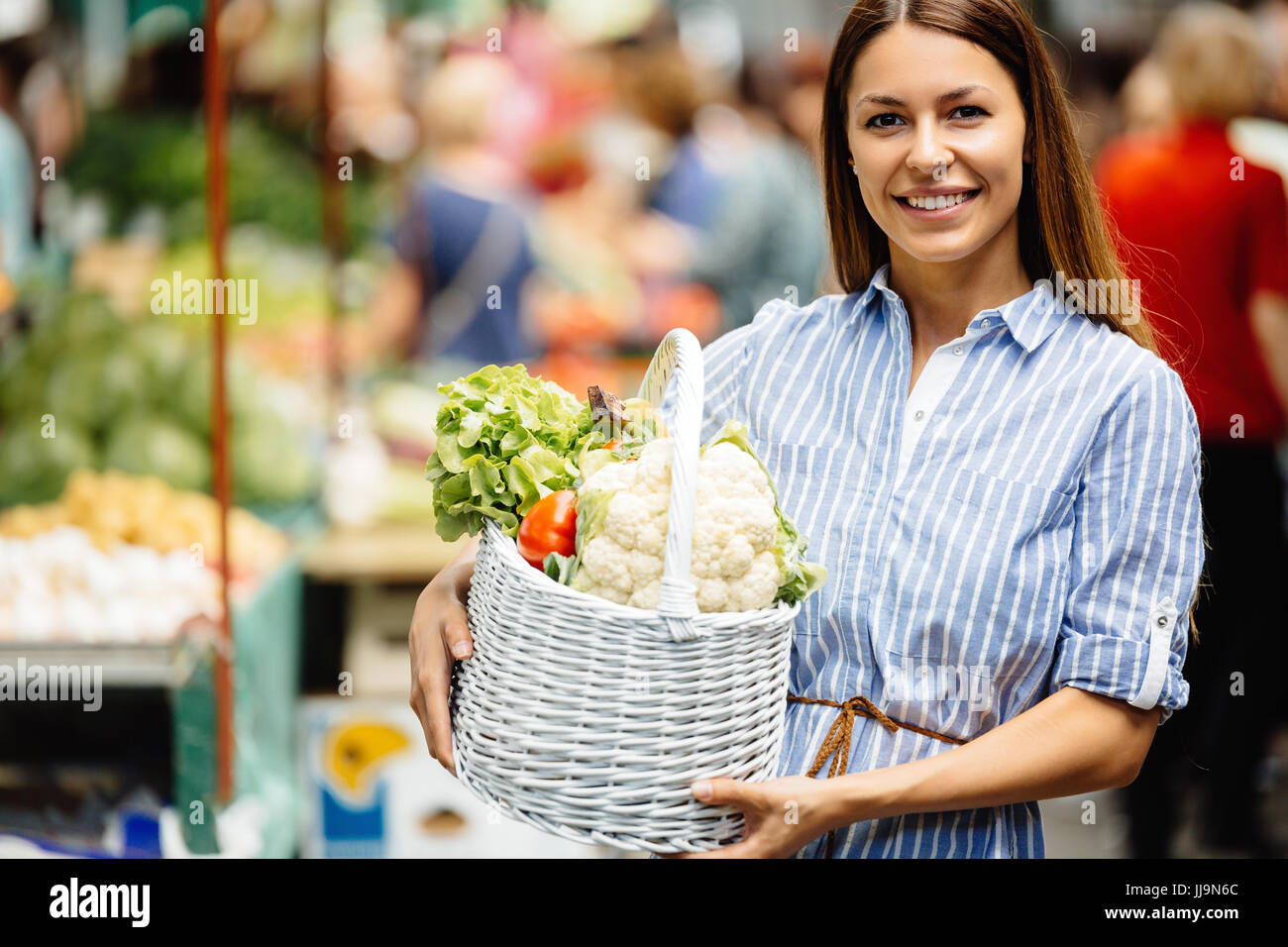 Portrait of beautiful woman holding shopping basket Stock Photo - Alamy