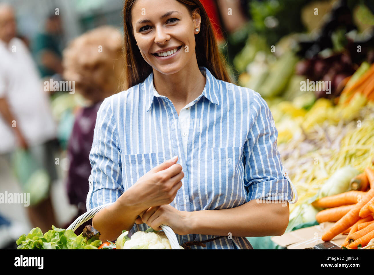 Portrait of beautiful woman holding shopping basket Stock Photo - Alamy