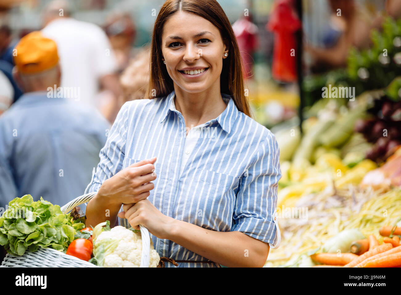 Portrait of beautiful woman holding shopping basket Stock Photo - Alamy