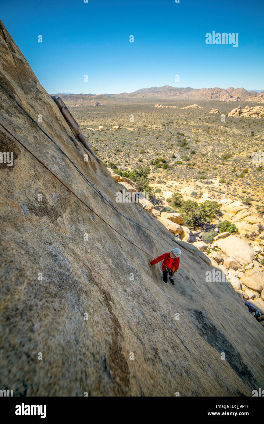 A young boy climbing a technical rock climb in Joshua Tree National