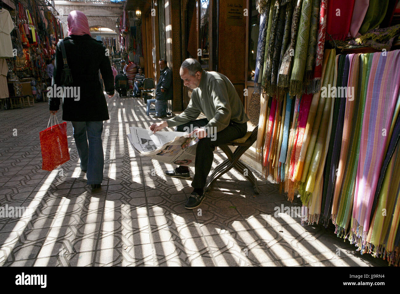 A merchant reads the newspaper in Marrakesh's medina quarter Stock Photo