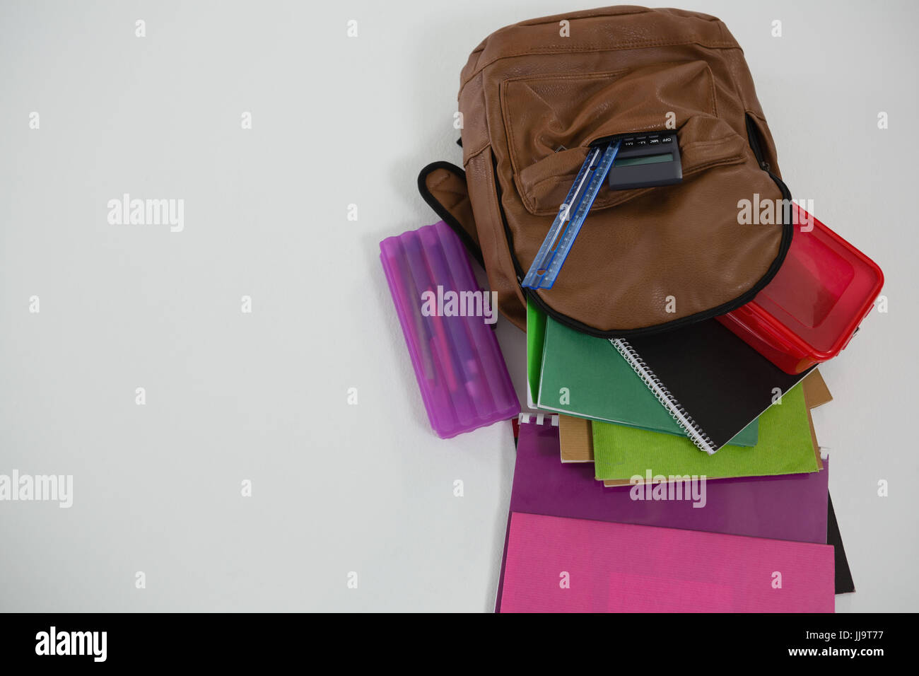 Overhead view of schoolbag with various supplies on white background Stock Photo