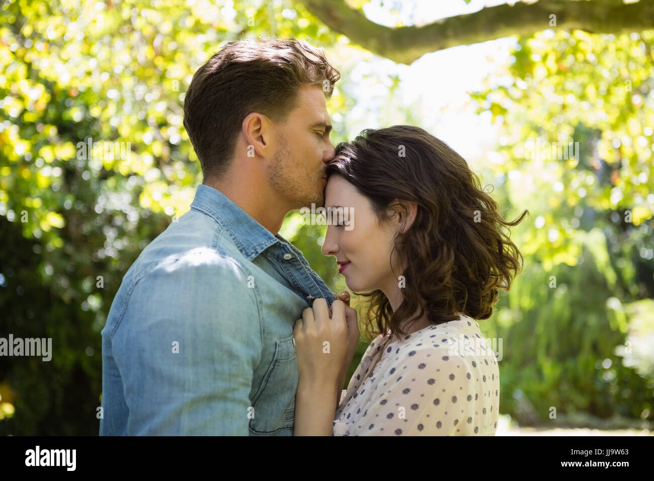 Man kissing woman on forehead in garden Stock Photo - Alamy, image size:1300x956