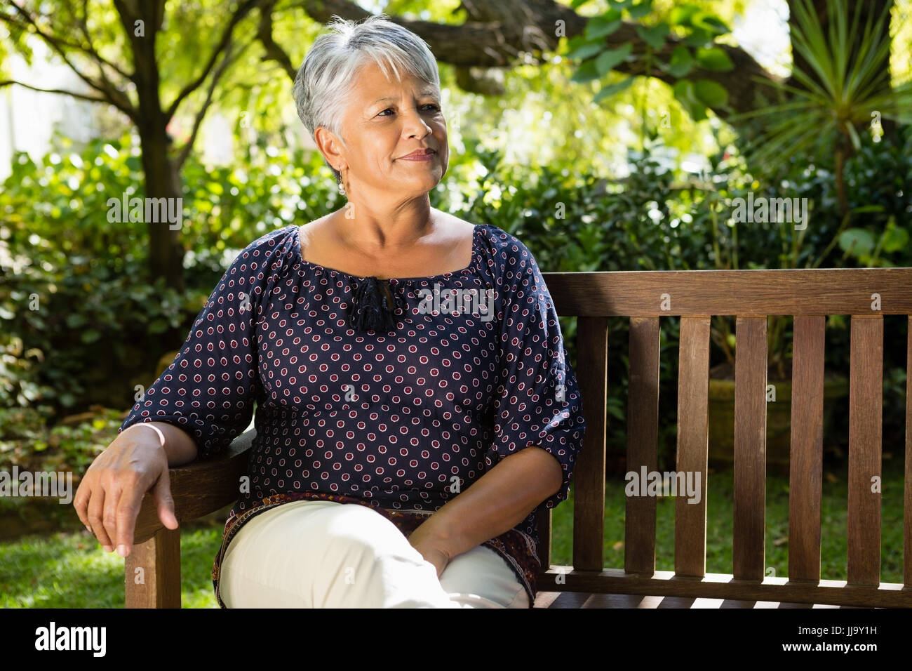 Senior woman sitting on a bench at the park Stock Photo - Alamy