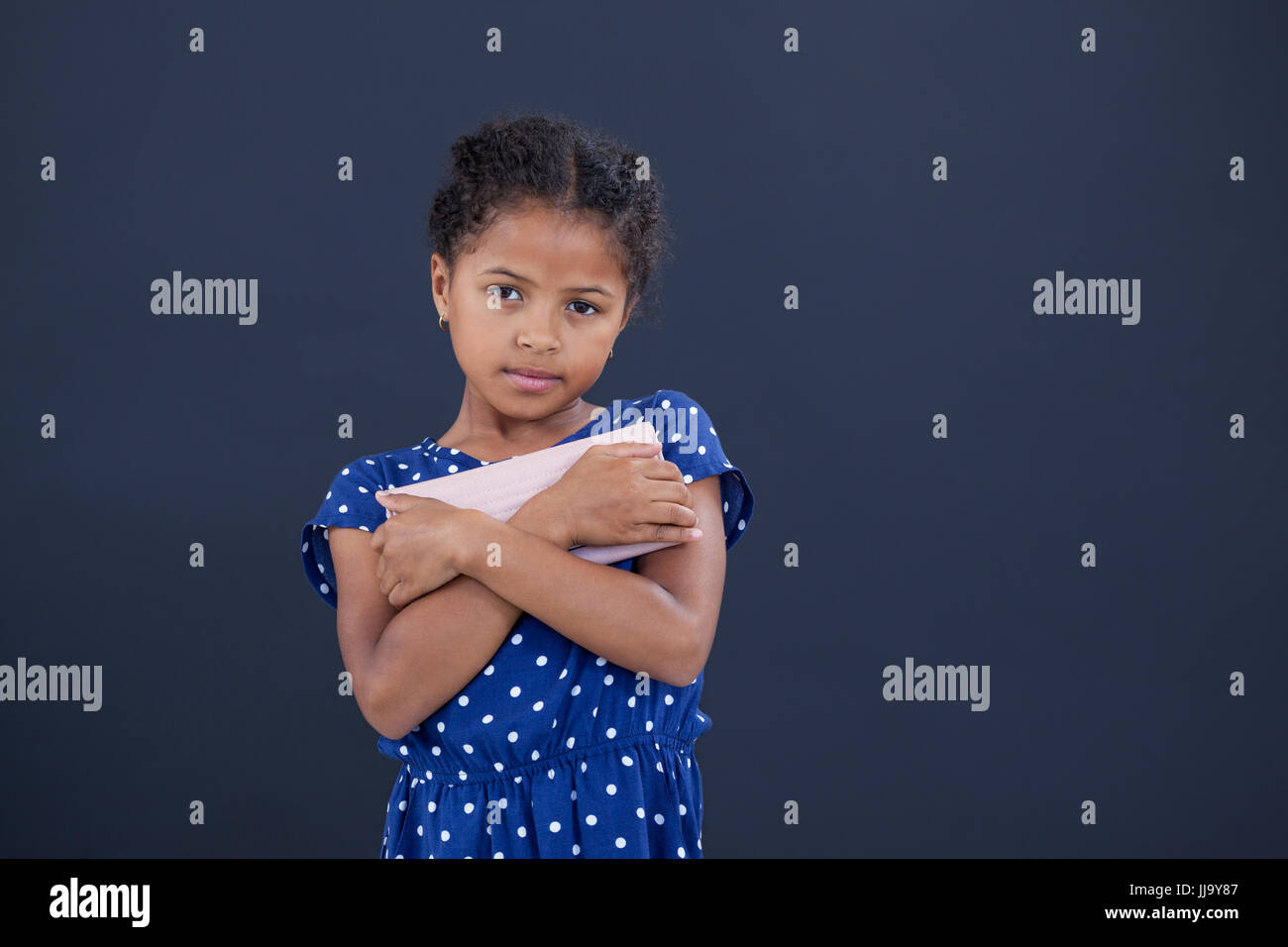 Portrait of girl holding purse while standing against white background