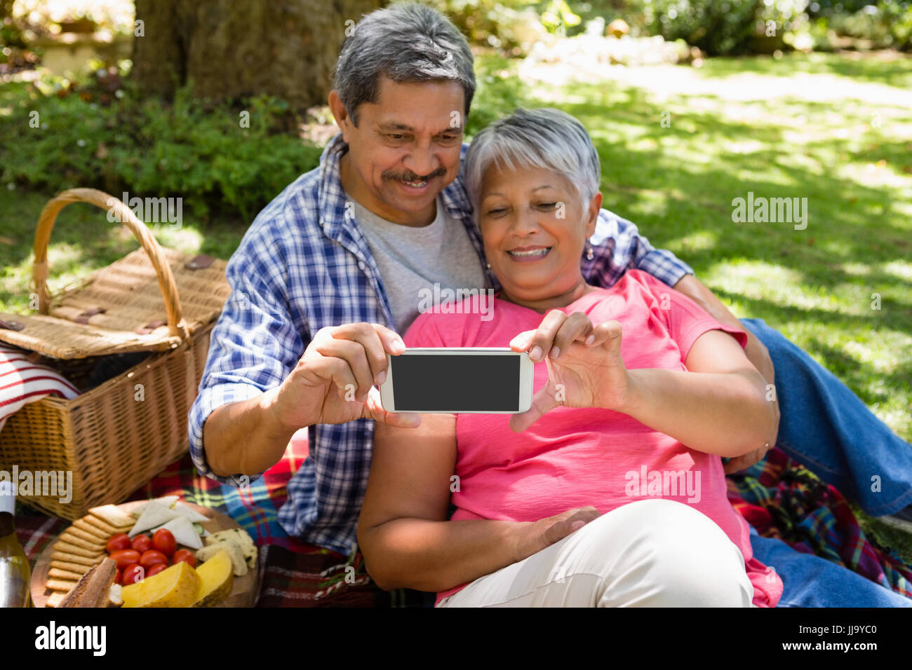 Senior couple taking a selfie at the park Stock Photo - Alamy