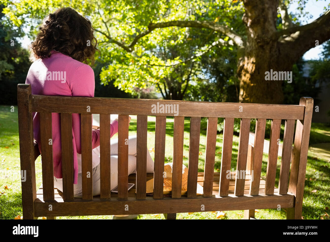 Woman sitting on bench and reading book at the garden Stock Photo - Alamy