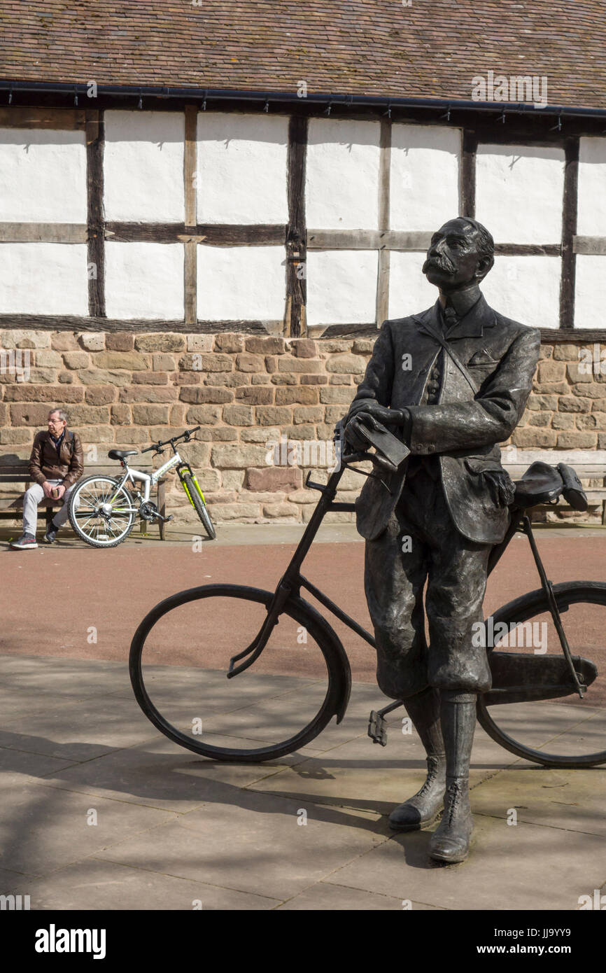 Bronze statue of Sir Edward Elgar resting on his bicycle, by Jemma Pearson, 2005, at Hereford Cathedral, with modern man and bicycle in background. Stock Photo
