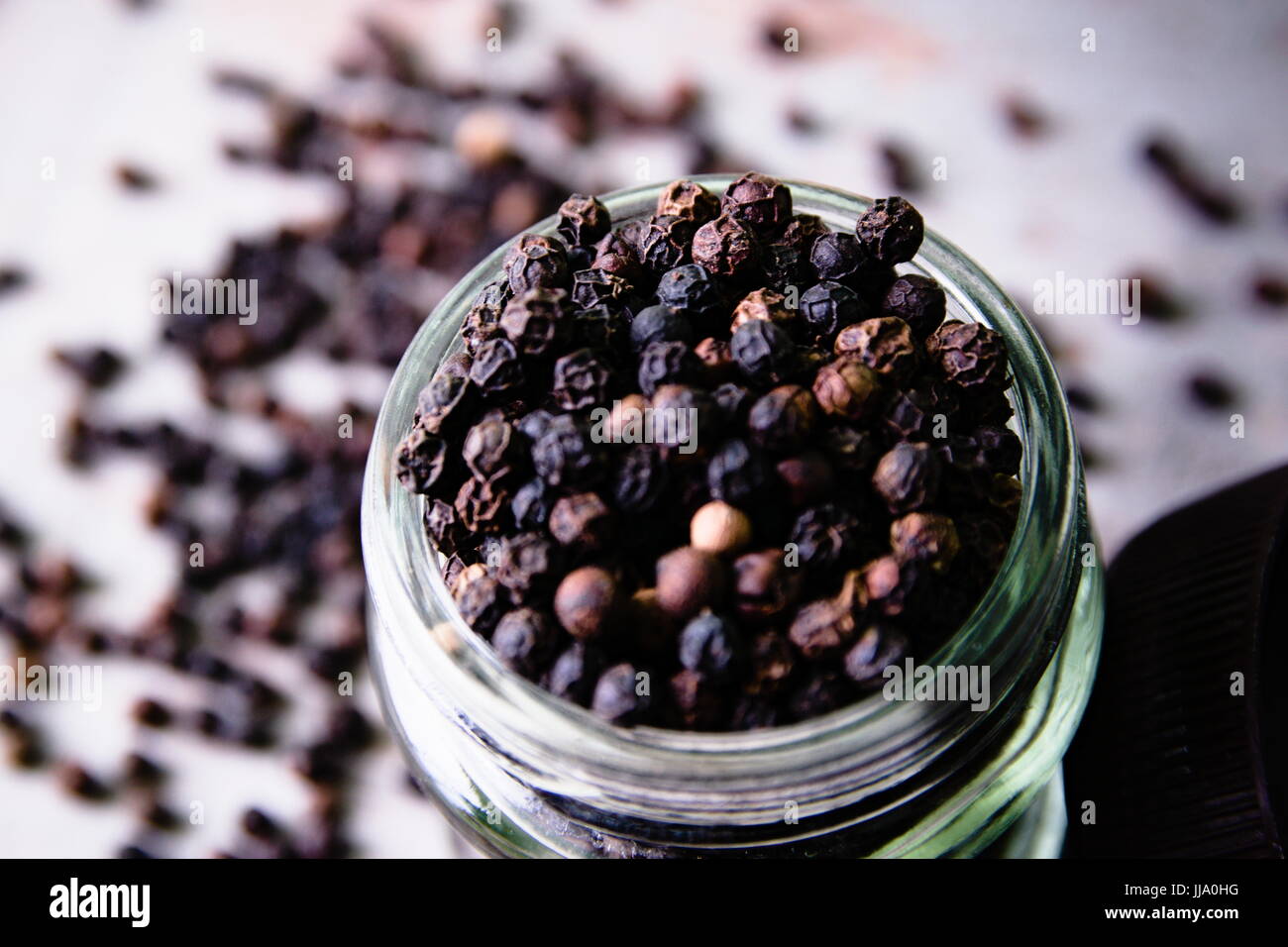 Spicy peppercorns in a glass jar on a wooden background Stock Photo Alamy