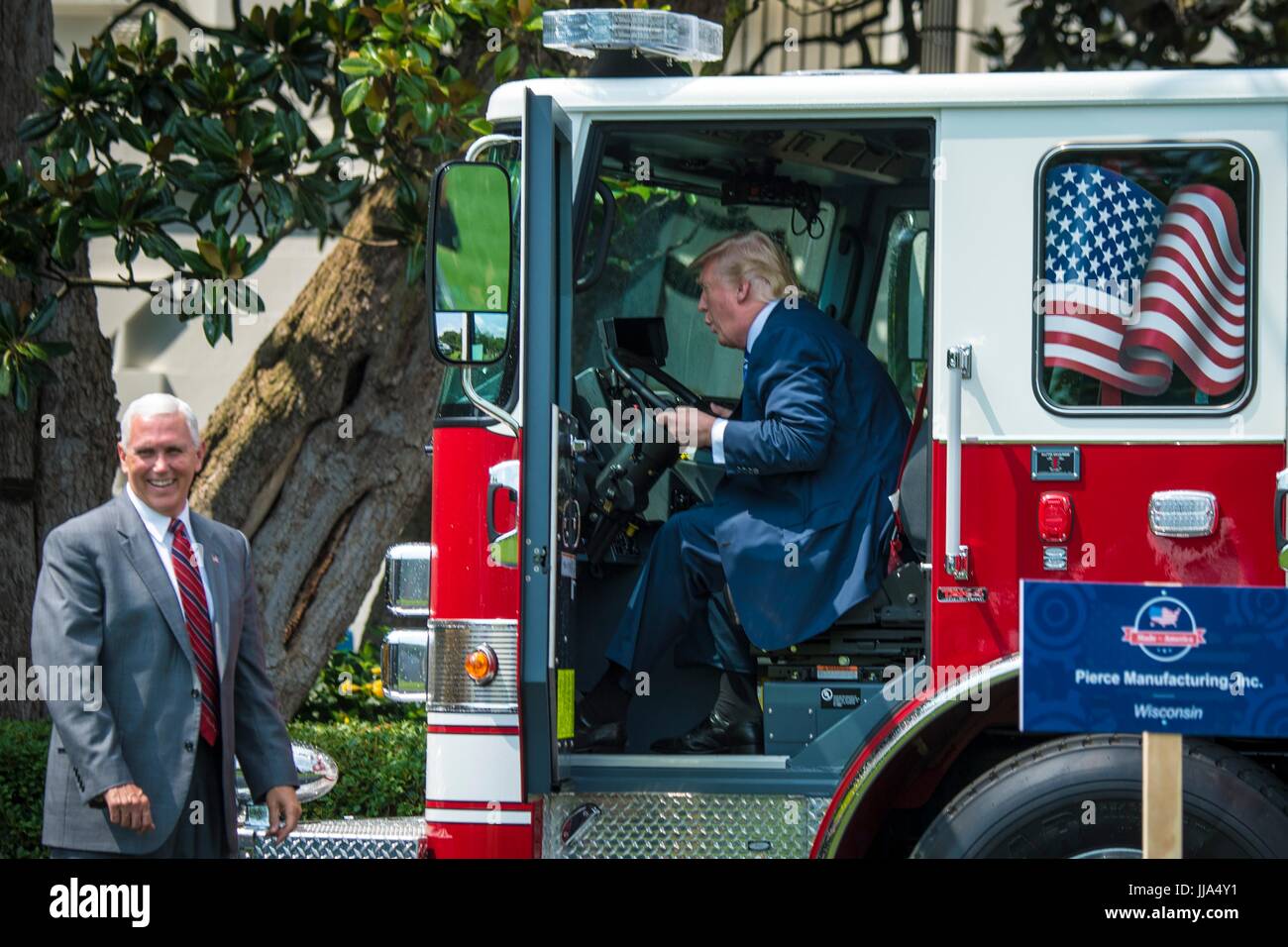 Washington, United States Of America. 17th July, 2017. U.S President Donald Trump sits behind the wheel of a Pierce fire truck as Vice President Mike Pence looks on during the Made in America Product Showcase on the South Lawn of the White House July 17, 2017 in Washington, DC. Credit: Planetpix/Alamy Live News Stock Photo