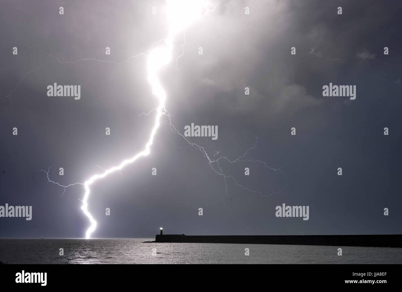 Newhaven, East Sussex. 19th July 2017. Dramatic display of lightning over the English Channel as summer storms bring torrential rain to the South East. © Peter Cripps/Alamy Live News Stock Photo