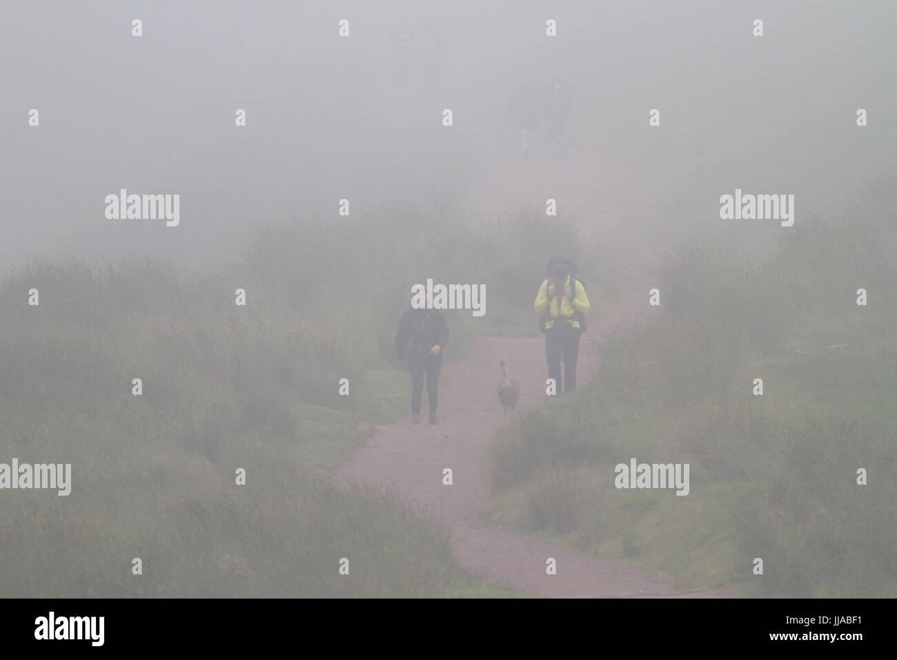 Pont Yr Daf, Brecon Beacons, South Wales, UK. 19th July, 2017. UK Weather: People walk the decent from Pen Y Fan in severe fog today, as humid temperatures reach in the low 30's in parts of the country. Credit: Andrew Bartlett/Alamy Live News Stock Photo