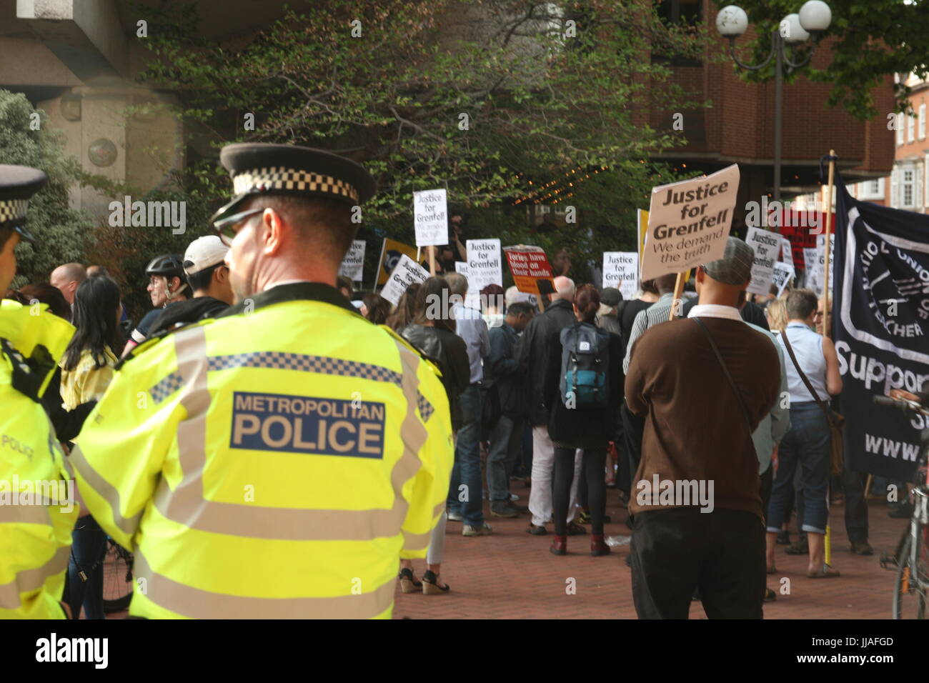 London, UK. 19th July 2017. Police look on as  protests take place outside the Kensington and Chelsea Council building as the council meets to  discuss the Grenfell disaster a month after it happened. Roland Ravenhill/Alamy Live News. Credit: Roland Ravenhill/Alamy Live News Stock Photo