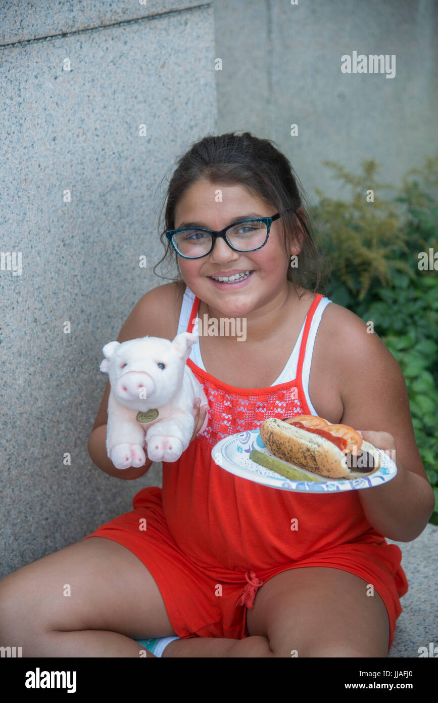 Washington, USA. 19th July, 2017. Ashton Sanchez, age 10, from Port Clinton, OH enjoys a veggie hot dog with all the trimmings and a gift stuffed pig, at the PETA annual Veggie Hot Dog lunch on Capitol Hill in Washington DC. Members of PETA (People for the Ethical Treatment of Animals) provide veggie "hot dogs" to Congressional staff members and visitors at the Rayburn House Office building in Washington DC. PETA holds its' annual veggie hot dog lunch at the same time as the annual Hot Dog day on Capitol Hill. Credit: Patsy Lynch/Alamy Live News Stock Photo