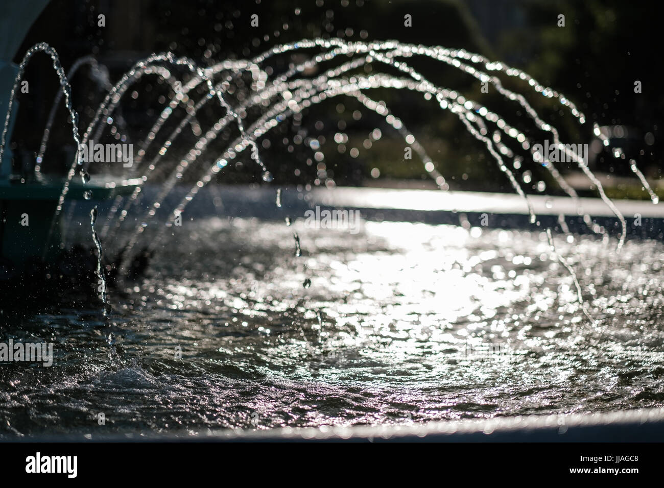 Water of dry fountain in the park close-up. Splashes fly in different directions. Stock Photo