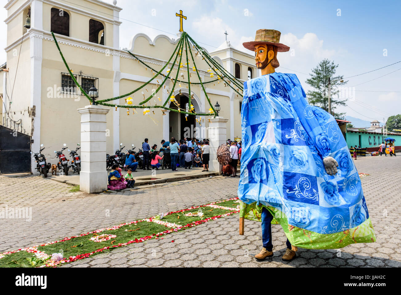 Parramos, Guatemala -  May 29, 2016: Giant puppet folk dancer called a gigante walks past church during Corpus Cristi mass Stock Photo