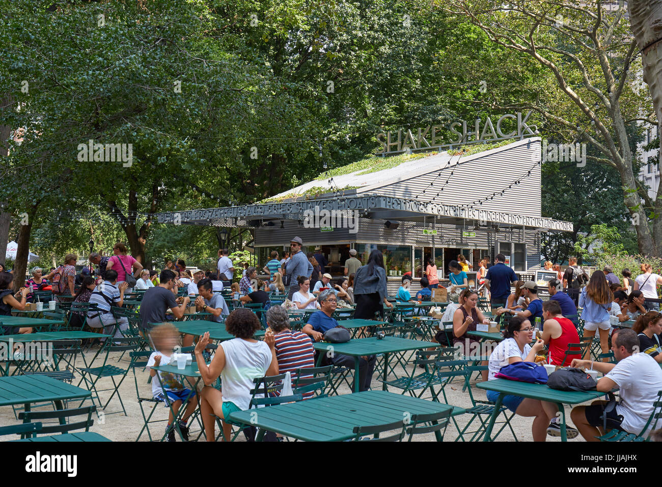 Shake Shack restaurant in Madison Square Park with people sitting, outdoor tables in summer in New York Stock Photo