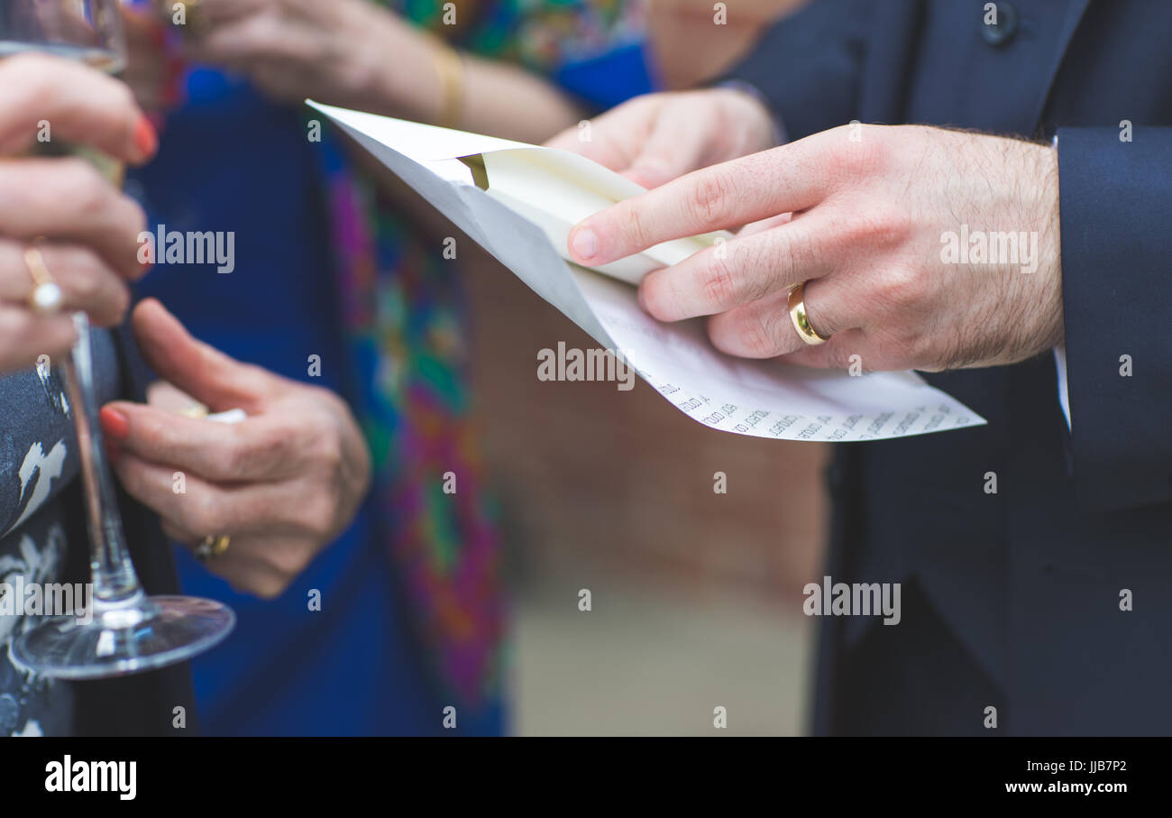 Just Married - The Groom's hand and the Wedding Certificate Envelope Stock Photo