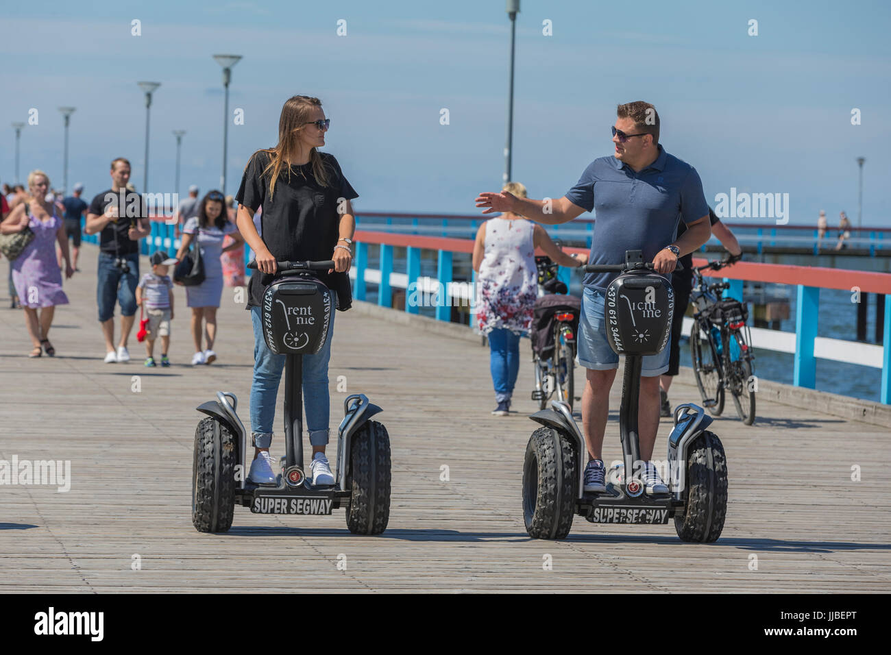 A young couple moves on the segway, Palanga, Lithuania. Stock Photo