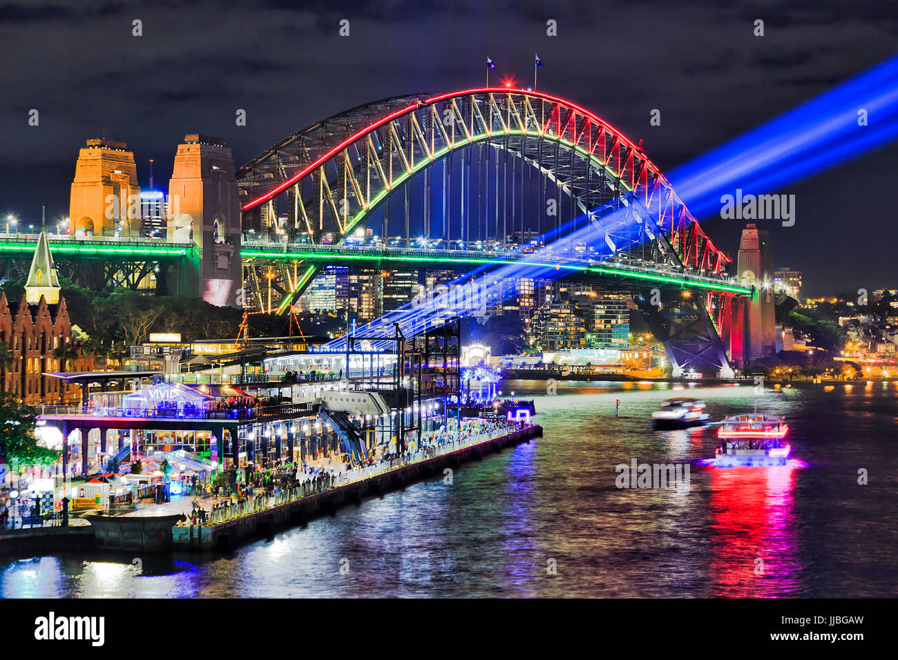 Sydney harbour bridge brightly illuminated and sending blue beams of projector light during Vivid Sydney light and ideas show in Sydney CBD as seen fr Stock Photo