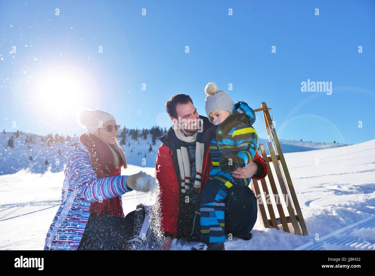 happy young family playing in fresh snow at beautiful sunny winter day ...