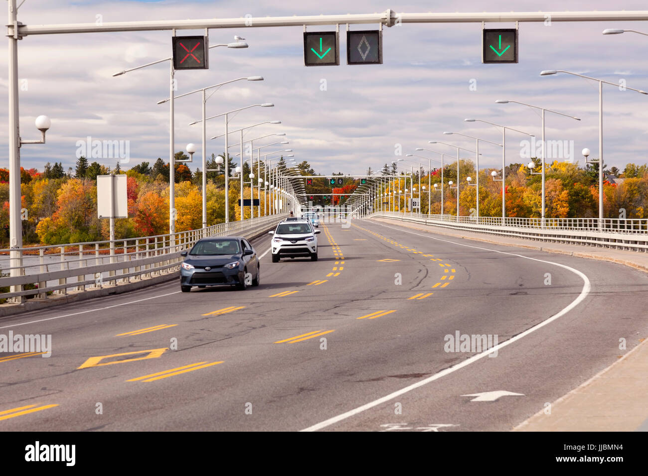 A reversible lane and illuminated signs showing traffic flow along the Champlain Bridge that crosses the Ottawa River from Ottawa to Gatineau. Stock Photo