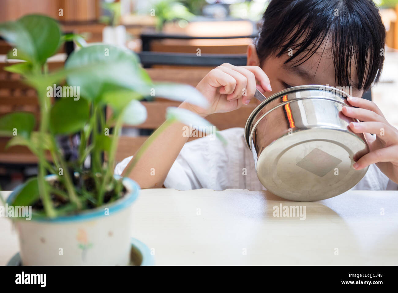 Asian Chinese little girl eating fried rice at outdoor cafe Stock Photo