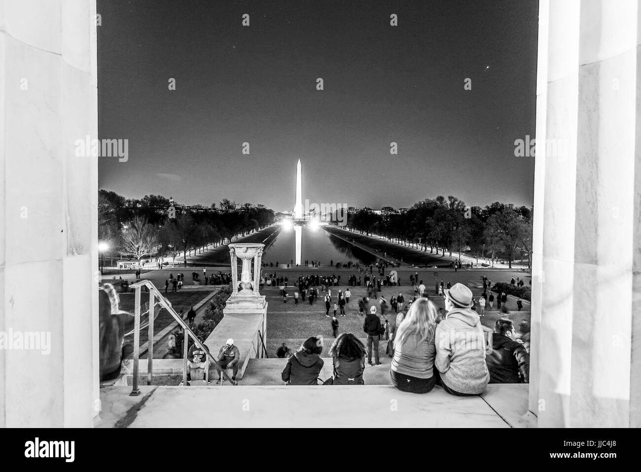 People sitting on the steps of Lincoln Memorial in Washington and view over reflecting pool - WASHINGTON DC - COLUMBIA - APRIL 9, 2017 Stock Photo