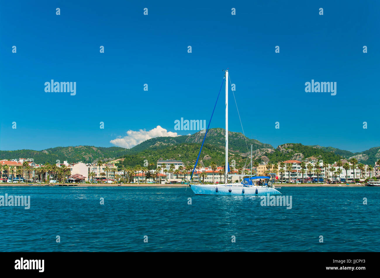 white yacht near city beach and hotels with mountains at back, Marmaris, Turkey Stock Photo
