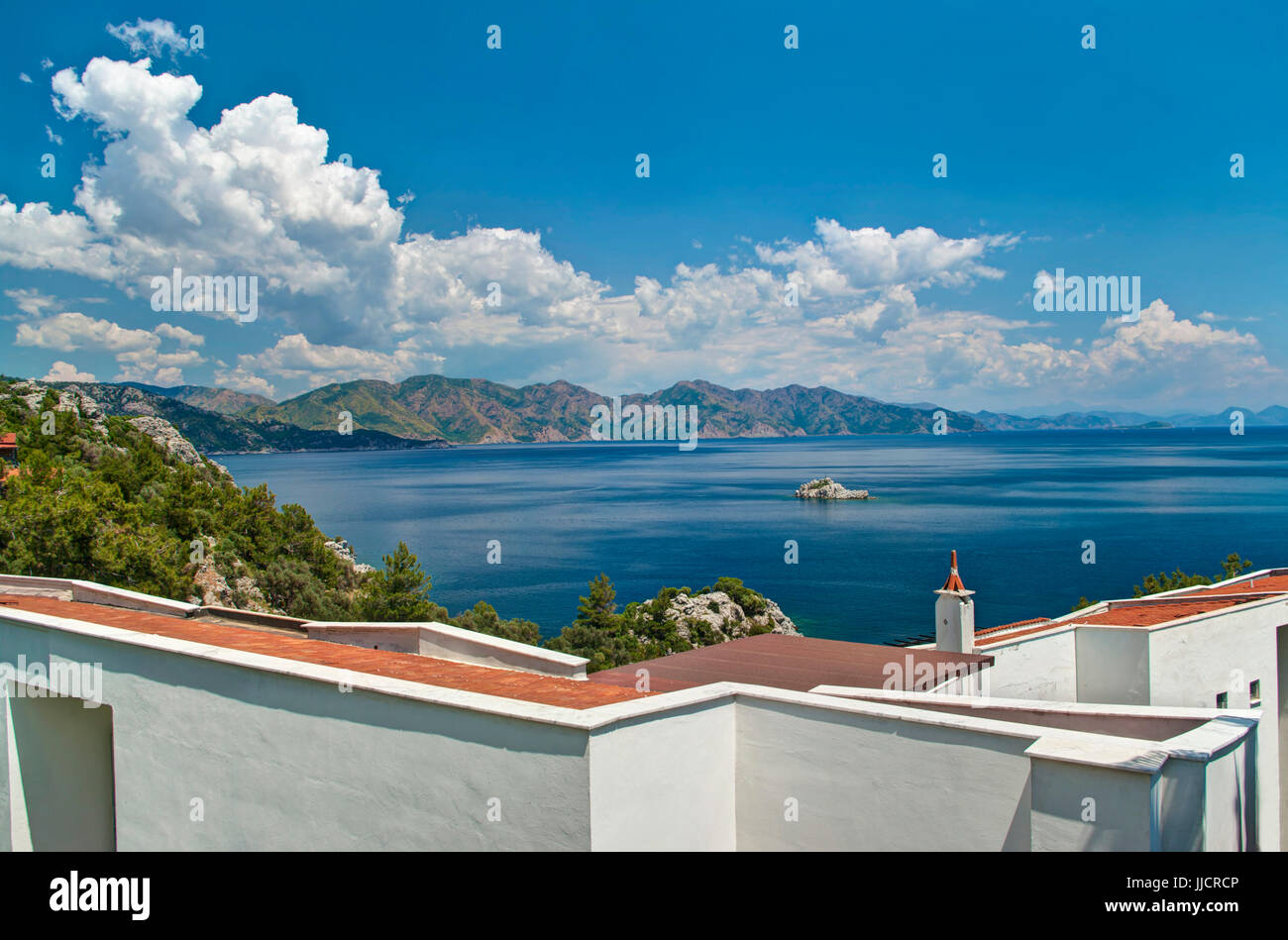 white greek house roof with sea view against blue sky on sunny day, Profesörler Sitesi, Turunc, Turkey Stock Photo