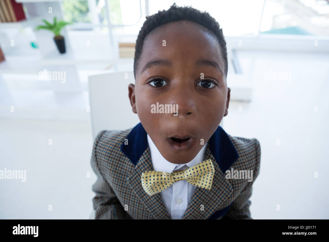 Close up portrait of boy imitating as businessman in office Stock Photo