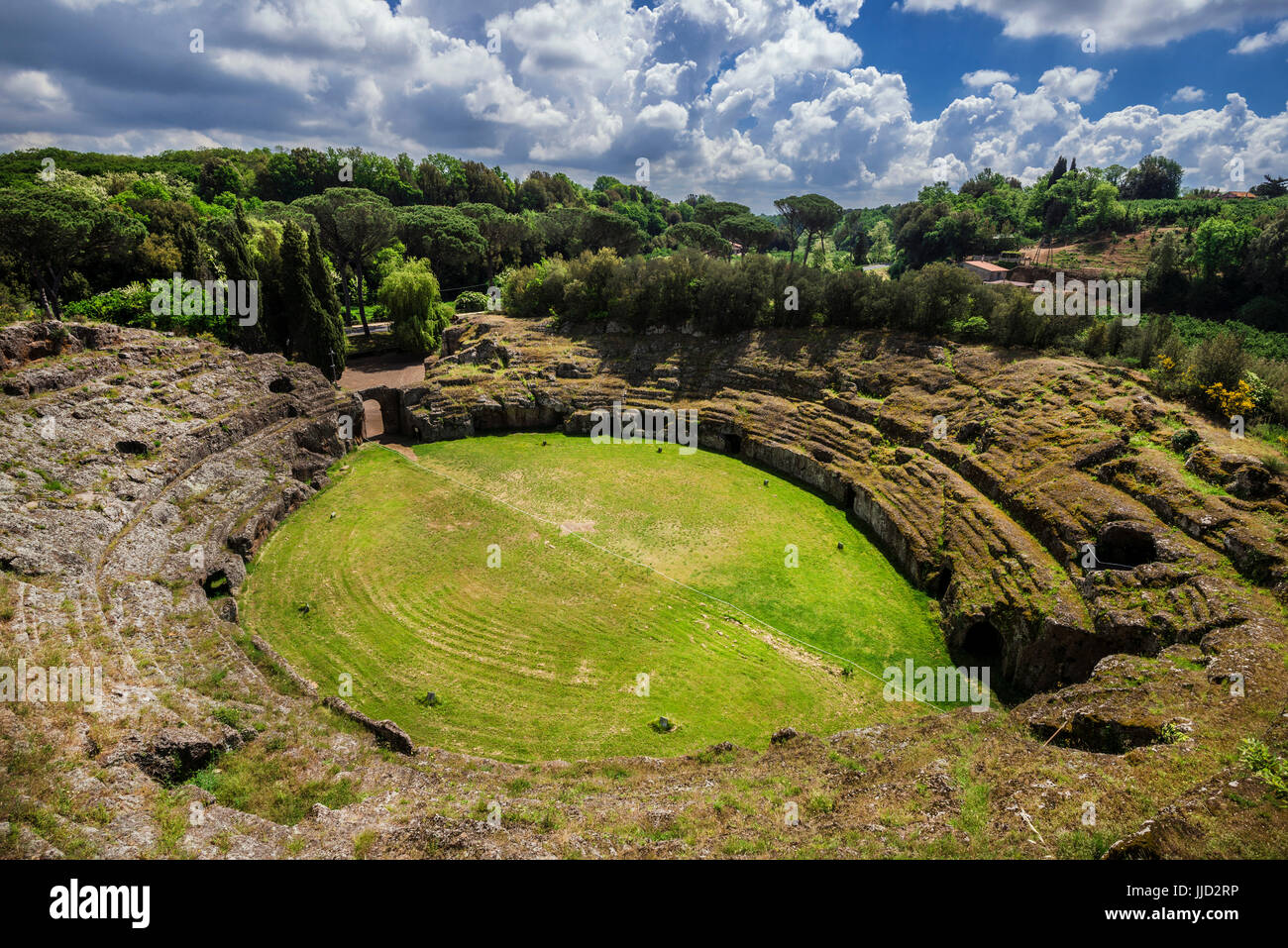 Ancient roman tuff stone amphitheater in the town of Sutri with clouds, near Rome Stock Photo