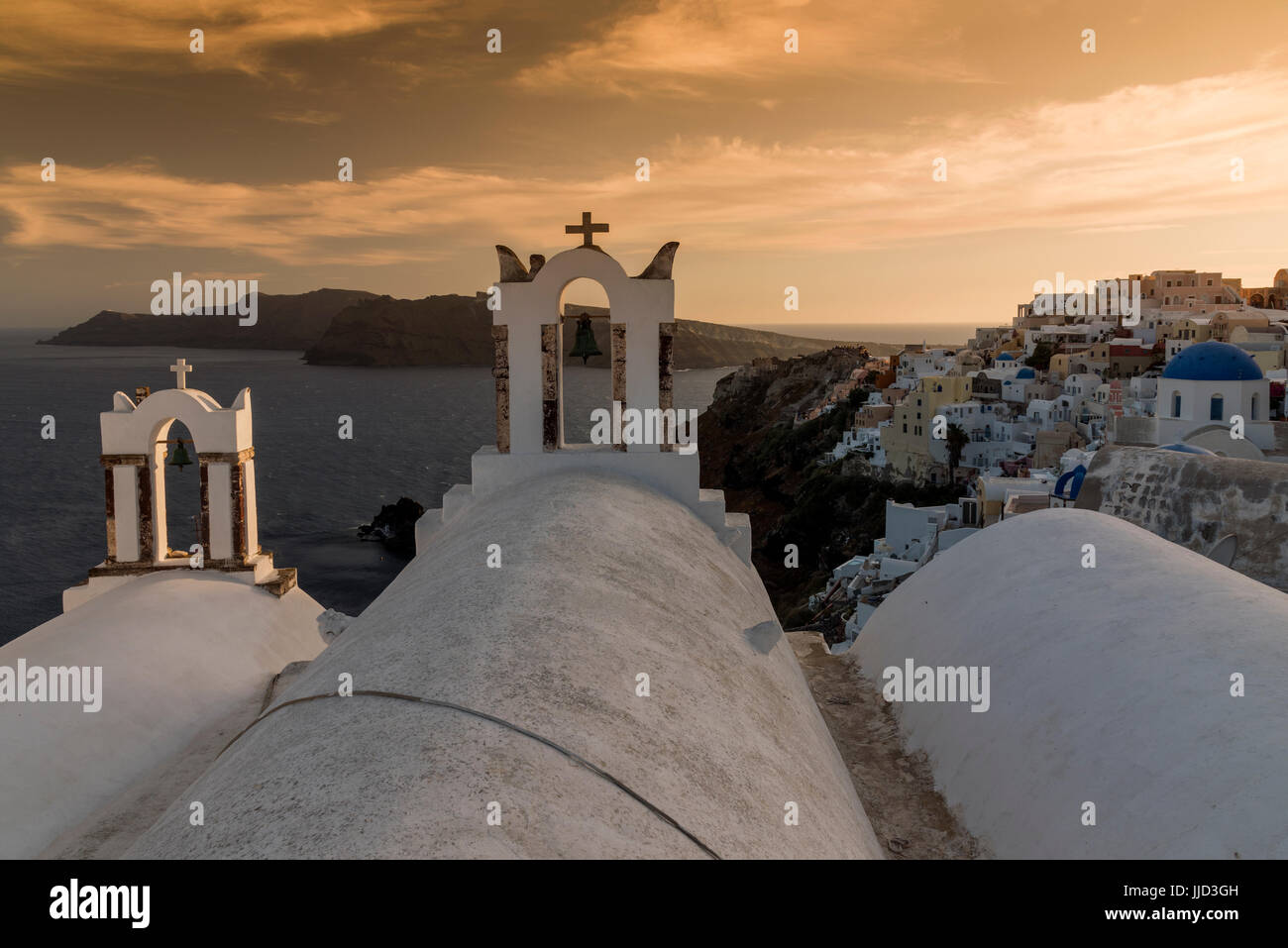 Sunset view with traditional Greek belfries and Oia in the background, Santorini, South Aegean, Greece Stock Photo