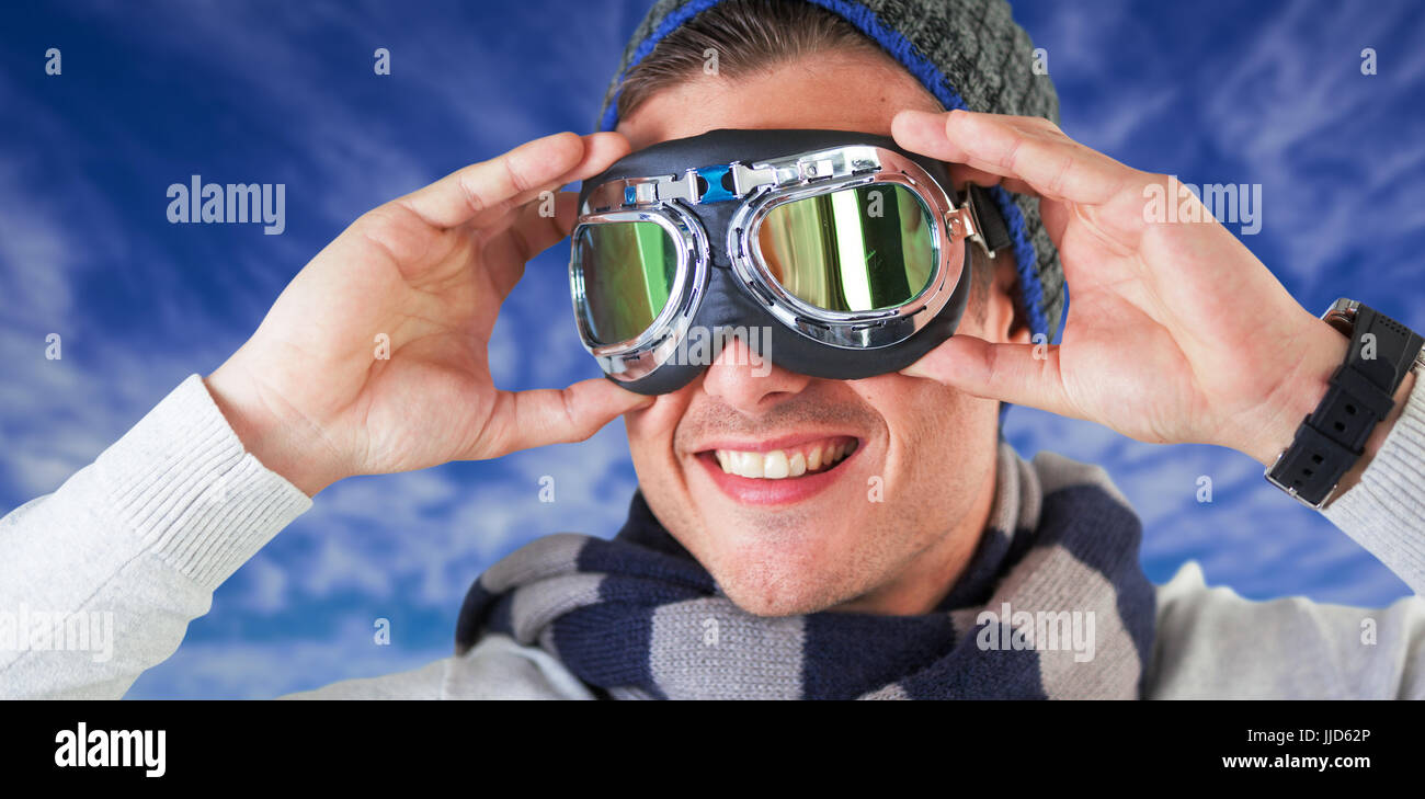 Happy man wearing aviator goggles against view of the blue sky Stock Photo