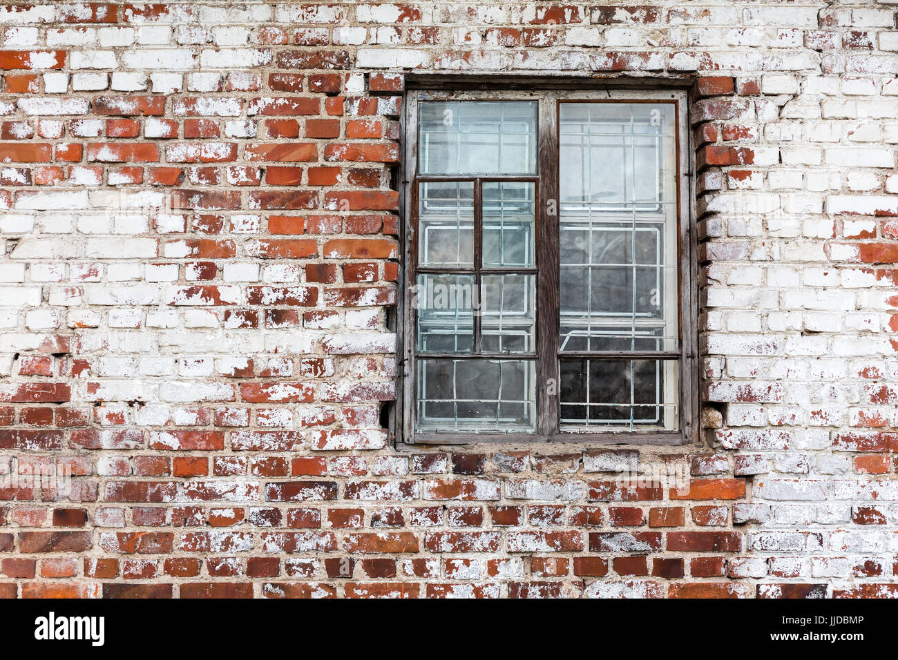 aged wooden window on weathered red brick wall painted white Stock Photo