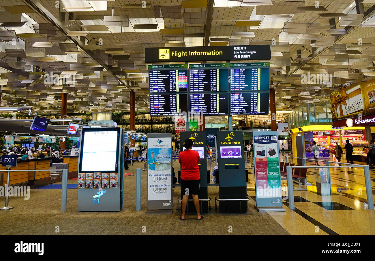 Singapore - Jun 14, 2017. People looking at information in Changi Airport, Singapore. Changi serves more than 100 airlines flying to some 380 cities i Stock Photo