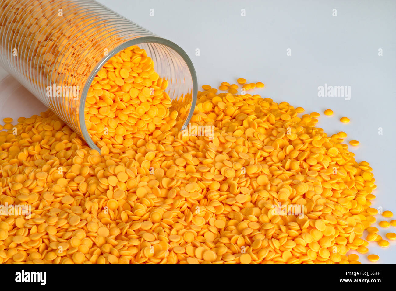 Polypropylene beads, plastic orange pellets on white color background. Stock Photo