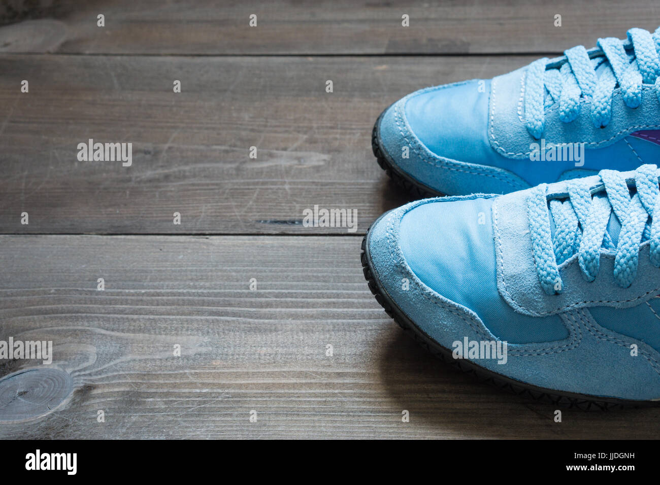 womens running blue sneakers on dark brown background. copy space for your motivation inscription. low angle shot Stock Photo