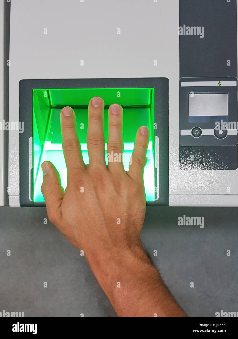 Top down view from a male hand using a fingerprint scanner for identification. Biometrics or cybersecurity concepts. Stock Photo
