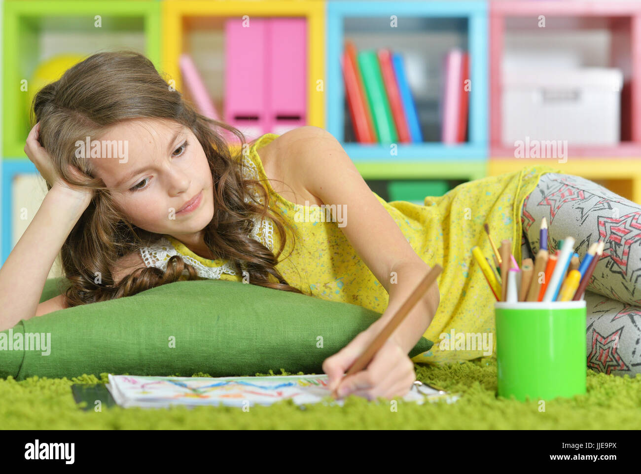 Little girl painting with pencil in her room  Stock Photo