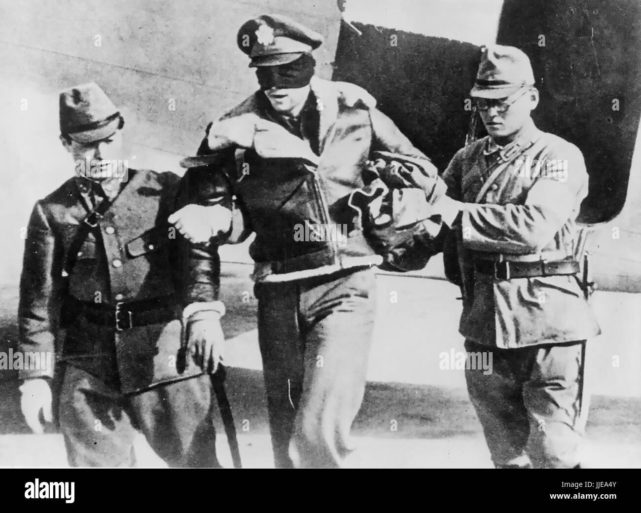 DOOLITTLE RAID ON TOKYO 18 April 1942. Captured US Army Airforce Lt Robert Hite, co-pilot of a B-25B from 34th Bomb Squadron,  is led from a Japanese transport plane. He was liberated from a Shanghai prison on 20 August 1945 Stock Photo